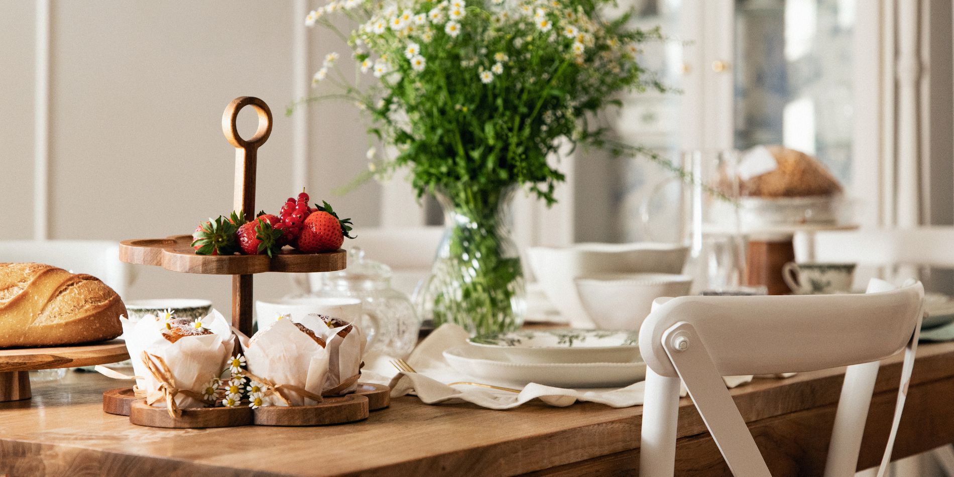 stół w jadalni nakryty w stylu cottage z drewnianymi akcesoriami do serwowania i porcelanową zastawą
